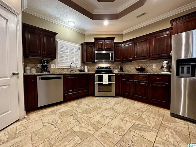 kitchen with stainless steel appliances, visible vents, a sink, and dark stone countertops