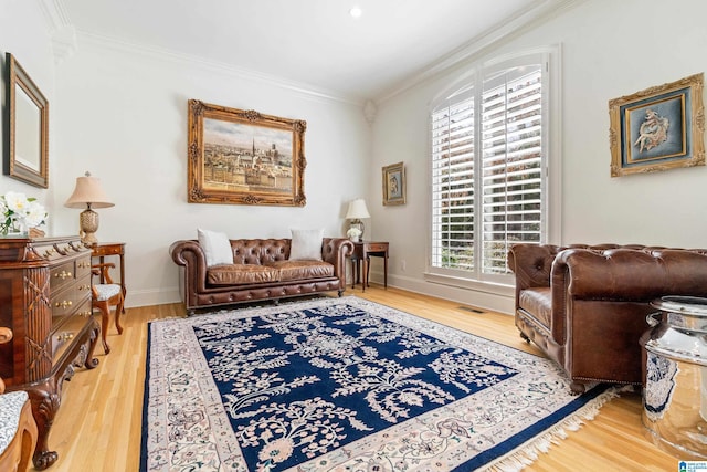 sitting room featuring visible vents, crown molding, baseboards, and wood finished floors