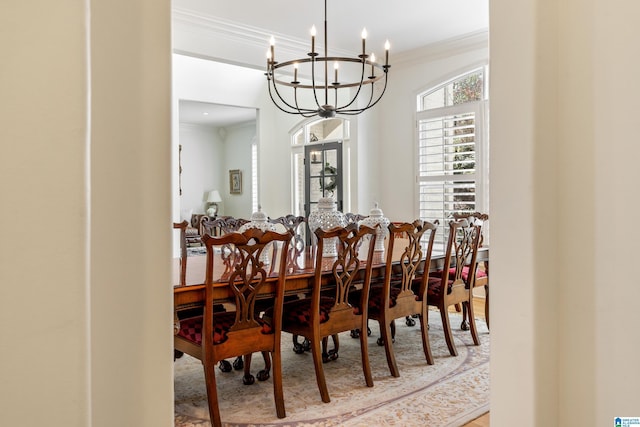 dining room with an inviting chandelier, wood finished floors, and ornamental molding