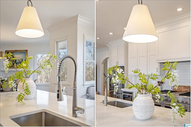 kitchen featuring decorative backsplash, crown molding, and a sink