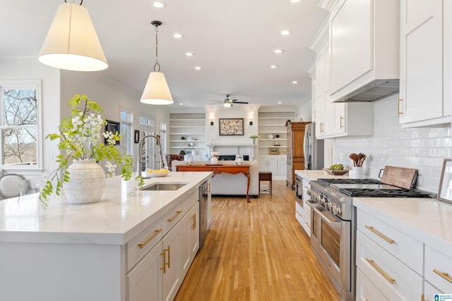 kitchen featuring custom range hood, a sink, stainless steel appliances, white cabinets, and crown molding