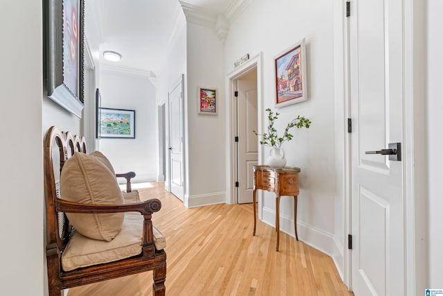 corridor with light wood-style flooring, baseboards, and ornamental molding