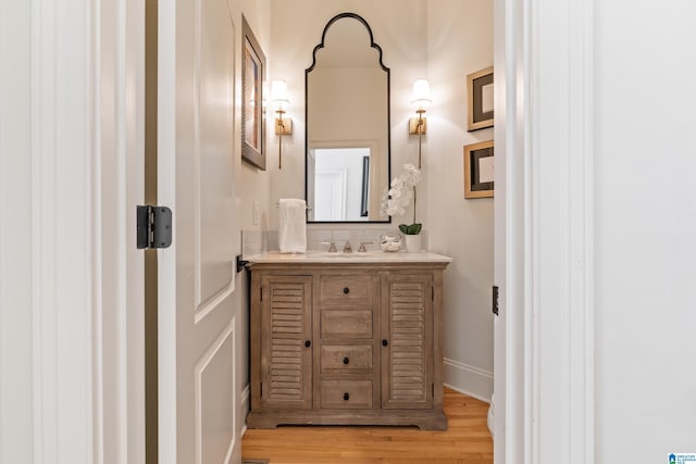 bathroom featuring vanity, baseboards, and wood finished floors