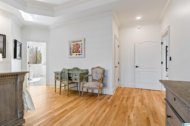 living area with crown molding, baseboards, light wood-type flooring, and visible vents