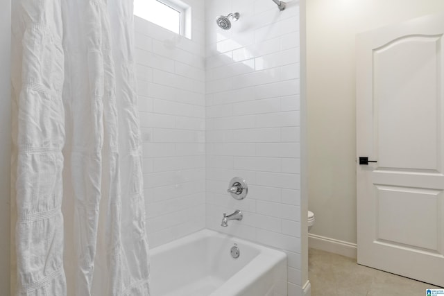 bathroom featuring tile patterned floors, toilet, baseboards, and shower / bath combo