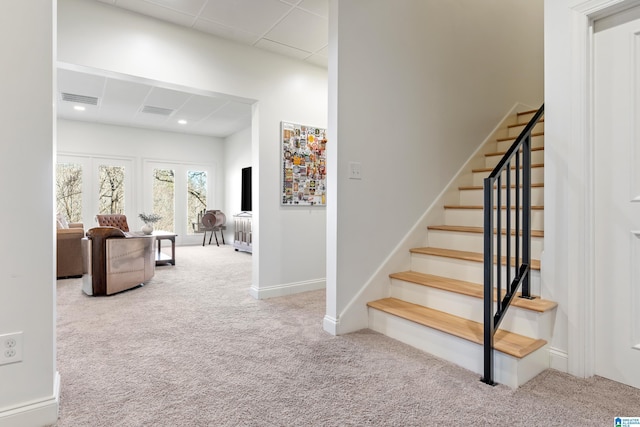 stairway with baseboards, visible vents, carpet floors, and a paneled ceiling