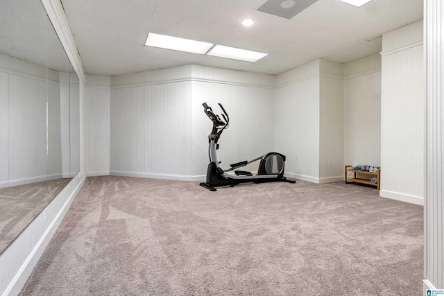 exercise area featuring a drop ceiling, baseboards, and carpet floors