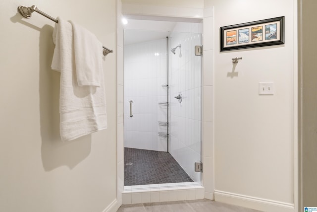 full bath featuring a stall shower and baseboards