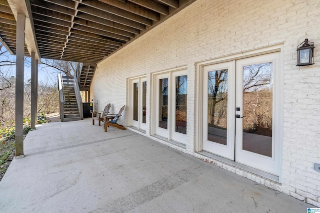 view of patio with french doors, central AC, and stairs