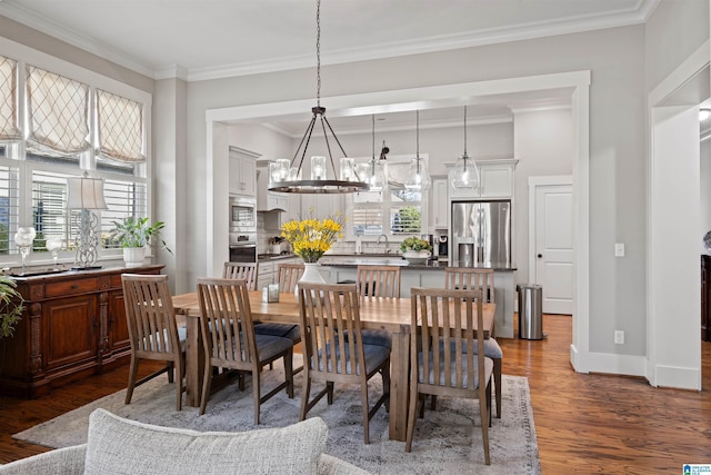 dining area with baseboards, wood finished floors, an inviting chandelier, and ornamental molding