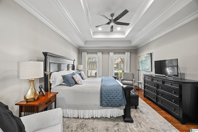 bedroom with dark wood finished floors, recessed lighting, crown molding, and a raised ceiling