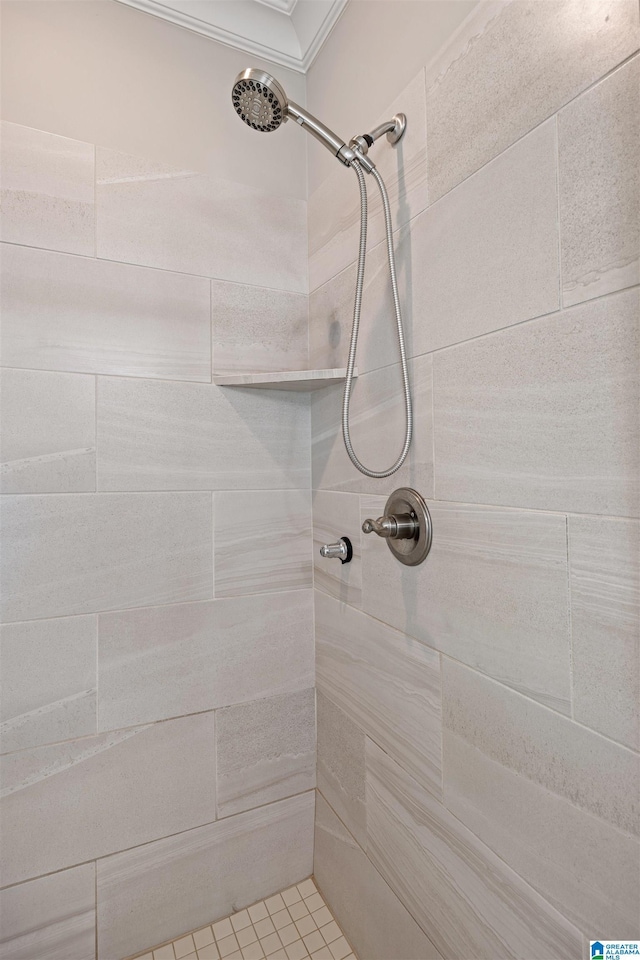 bathroom with tiled shower and ornamental molding