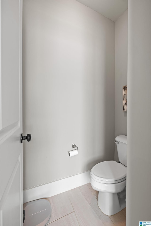 bathroom with baseboards and toilet