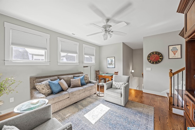 living area featuring visible vents, baseboards, ceiling fan, stairs, and wood finished floors