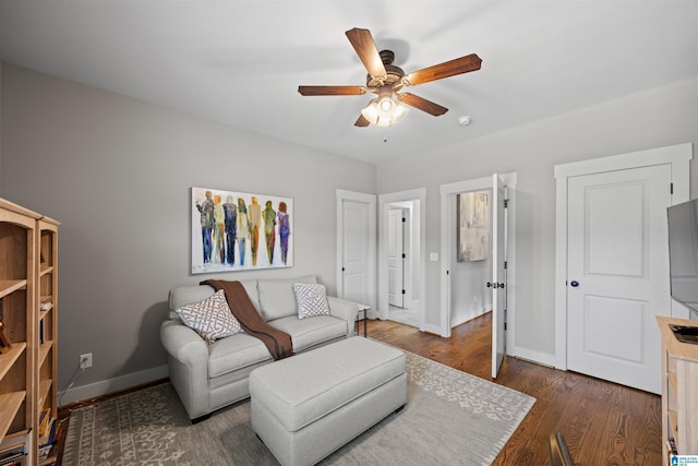 living room featuring wood finished floors, baseboards, and ceiling fan