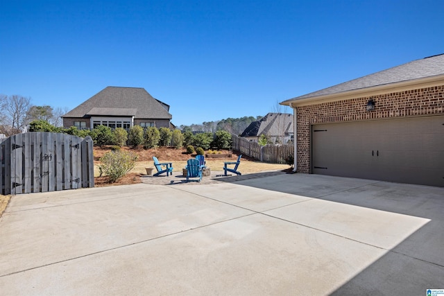 view of patio with driveway, a garage, and fence