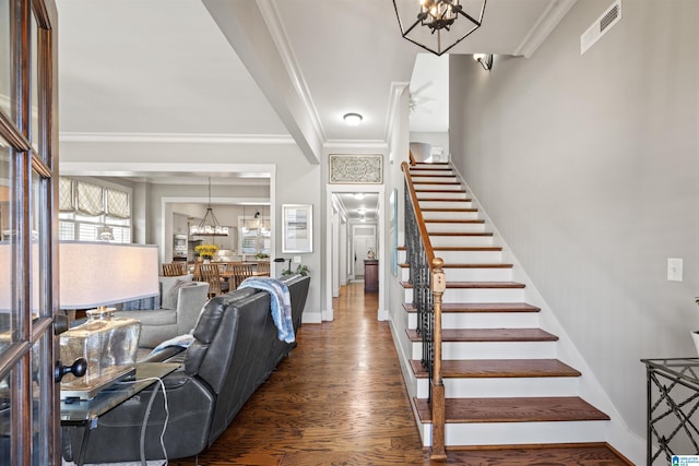 entrance foyer featuring stairway, wood finished floors, visible vents, an inviting chandelier, and crown molding