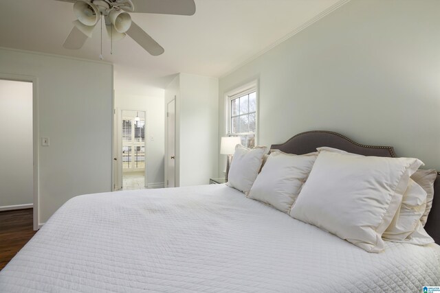 bedroom with a ceiling fan, crown molding, wood finished floors, and baseboards