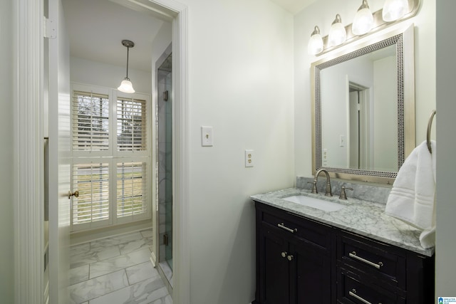 bathroom featuring marble finish floor, a shower stall, and vanity