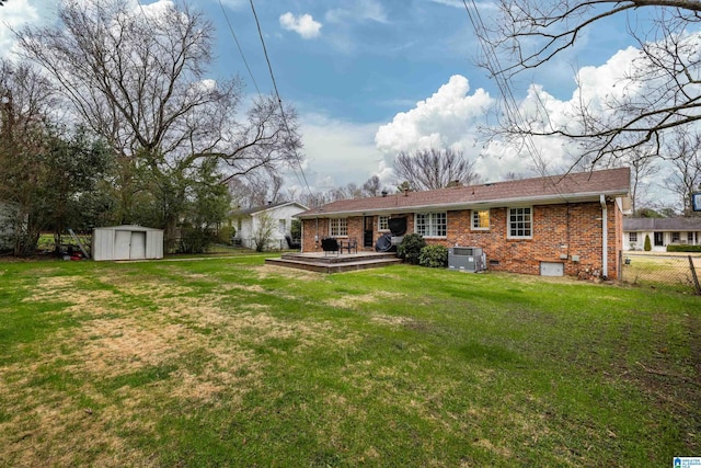 back of house featuring crawl space, a shed, a yard, and brick siding