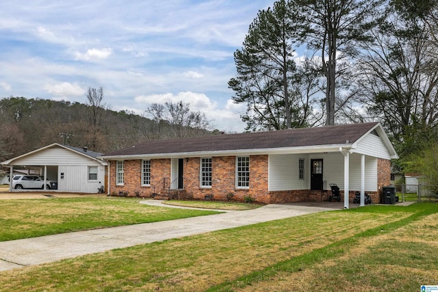 ranch-style house featuring brick siding, crawl space, concrete driveway, a front yard, and a carport