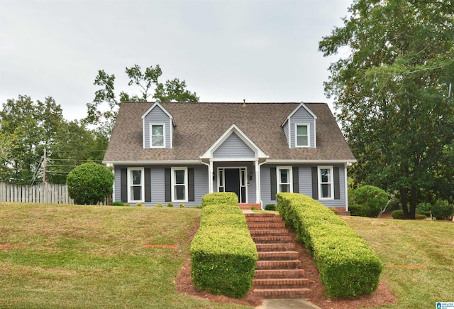 cape cod-style house with stairs, a front lawn, and a shingled roof