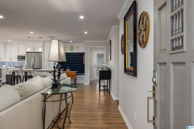 living area featuring crown molding, recessed lighting, wood finished floors, and baseboards