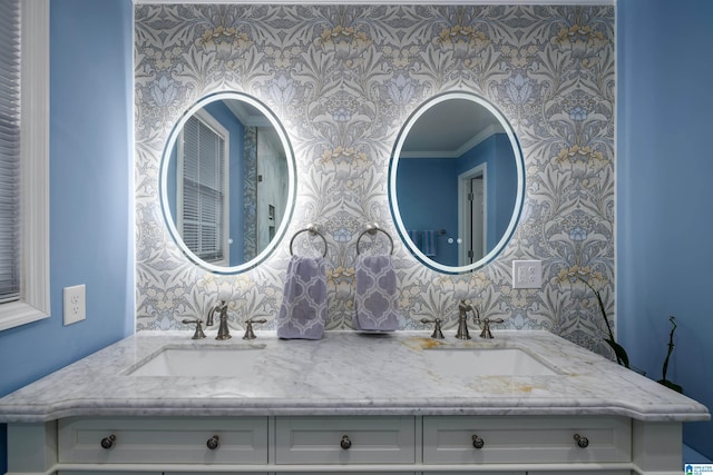 full bathroom featuring double vanity, wallpapered walls, and a sink