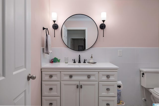 half bathroom featuring toilet, tile walls, and vanity