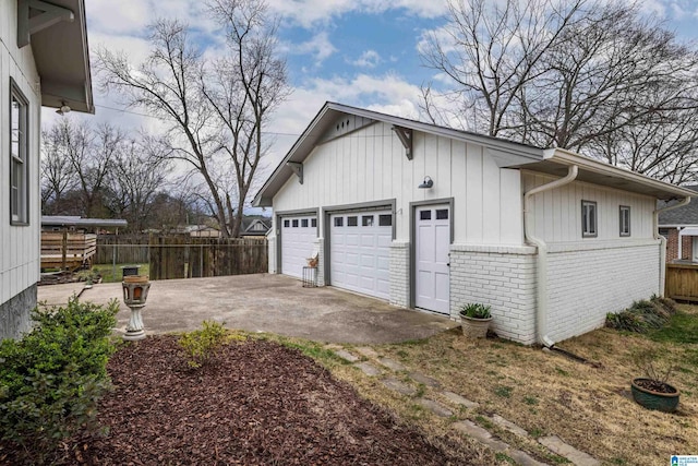 garage featuring driveway and fence