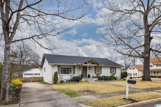 view of front of house with fence, brick siding, a front yard, and a shingled roof