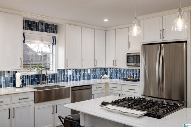 kitchen with a sink, tasteful backsplash, appliances with stainless steel finishes, and white cabinets