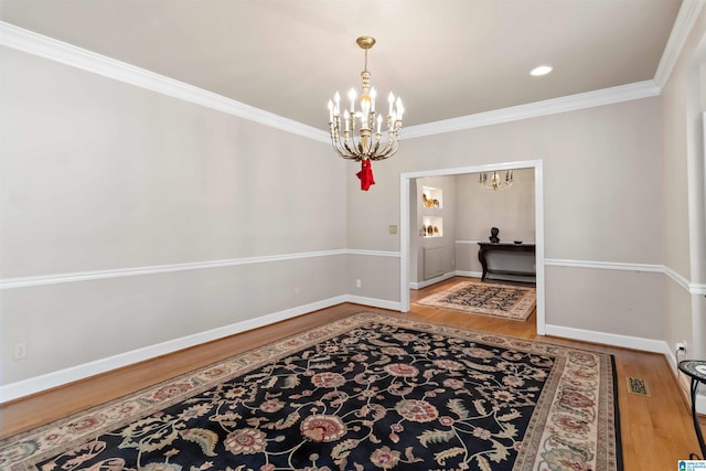 dining area with visible vents, baseboards, ornamental molding, an inviting chandelier, and wood finished floors