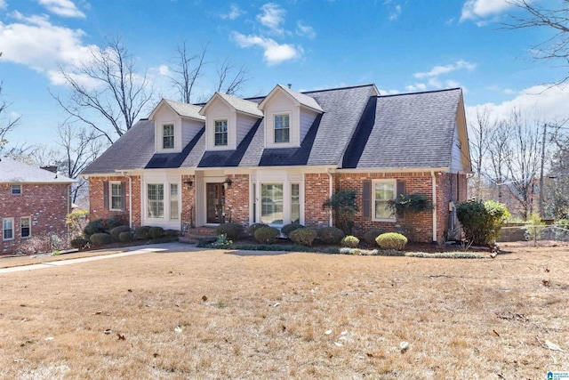 cape cod-style house featuring brick siding and roof with shingles