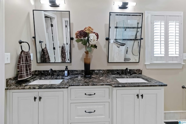 full bathroom featuring a sink, double vanity, and a shower stall