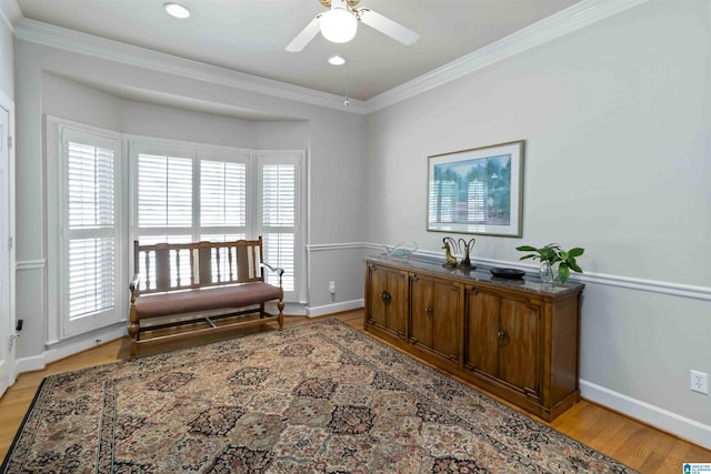 living area with light wood-style flooring, baseboards, and ornamental molding