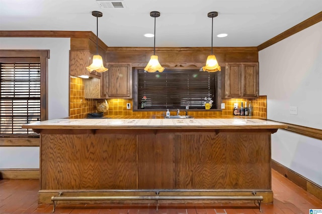 bar with visible vents, pendant lighting, backsplash, wood finished floors, and crown molding