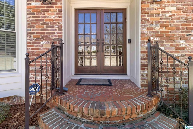 property entrance with brick siding and french doors