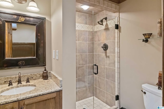 bathroom featuring vanity, toilet, and a stall shower