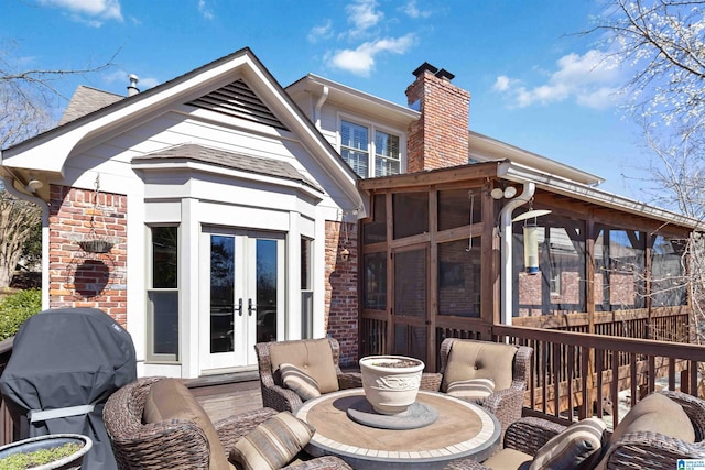 wooden terrace featuring area for grilling, french doors, and a sunroom