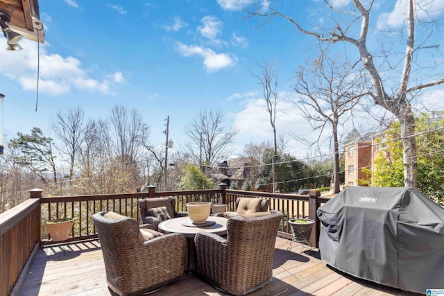 wooden terrace featuring area for grilling and outdoor dining space