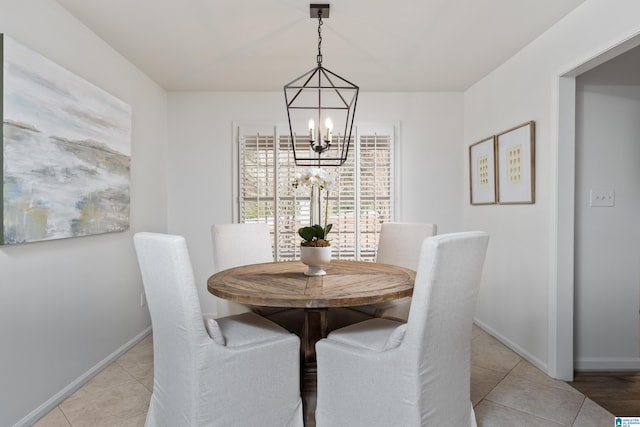 dining area with an inviting chandelier, light tile patterned floors, and baseboards