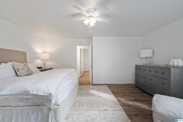 bedroom with ceiling fan, wood finished floors, and baseboards