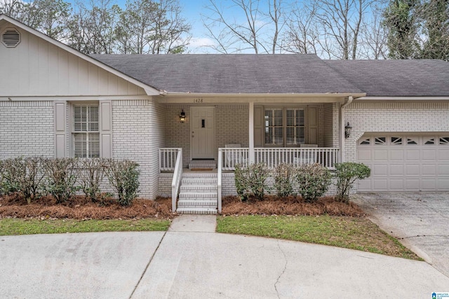 single story home with a porch, concrete driveway, brick siding, and a garage