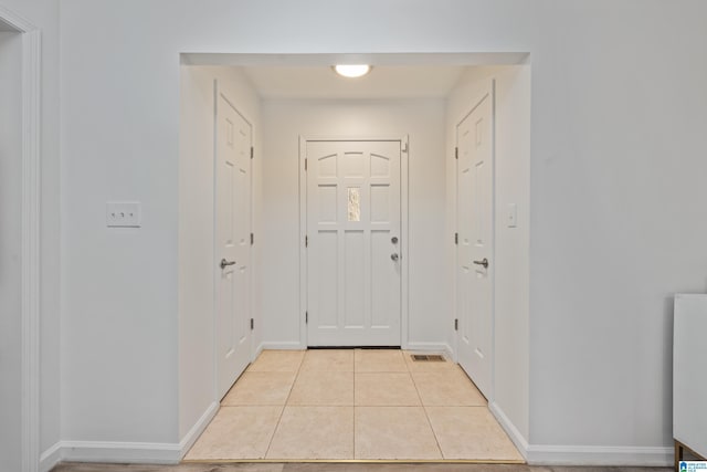 doorway featuring light tile patterned floors, visible vents, and baseboards