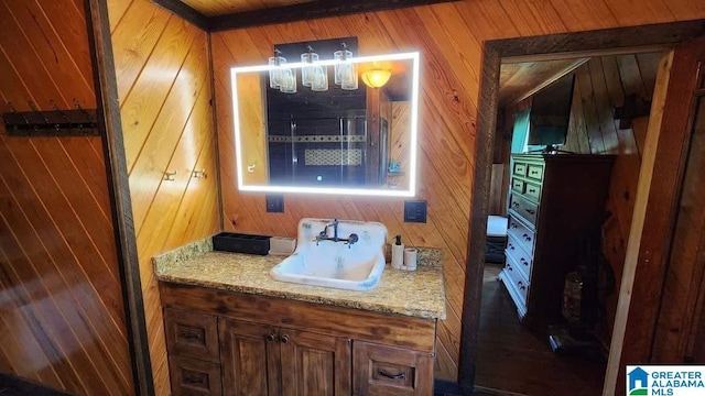 bathroom featuring wooden walls and vanity