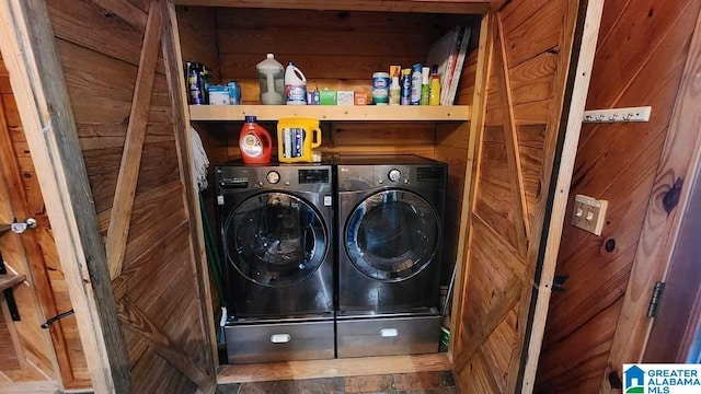 laundry room featuring laundry area, independent washer and dryer, and wooden walls