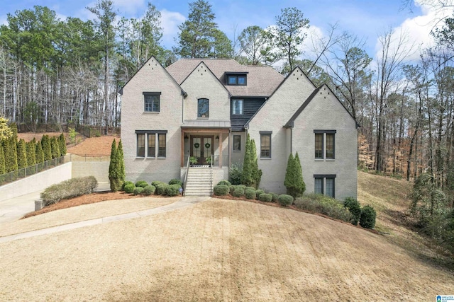 french provincial home featuring brick siding