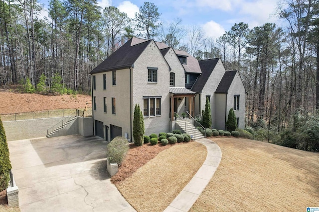 view of front of home featuring brick siding, concrete driveway, a standing seam roof, metal roof, and a garage