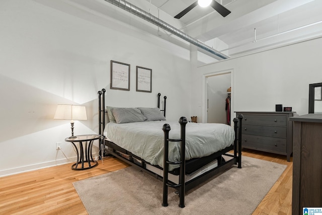 300 20th Ave N Unit 204, Birmingham, AL 35203 - bedroom featuring a walk in closet, light wood-style flooring, a ceiling fan, a closet, and baseboards